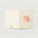 Carte de vœux ouverte à plat sur fond gris clair. La page de gauche est ivoire uni avec le logo Tricia Brière en bas à gauche. La page de droite, en beige rosé, est ornée d'un cercle rose poudré aux cernes concentriques blancs et d'une feuille verte stylisée.
