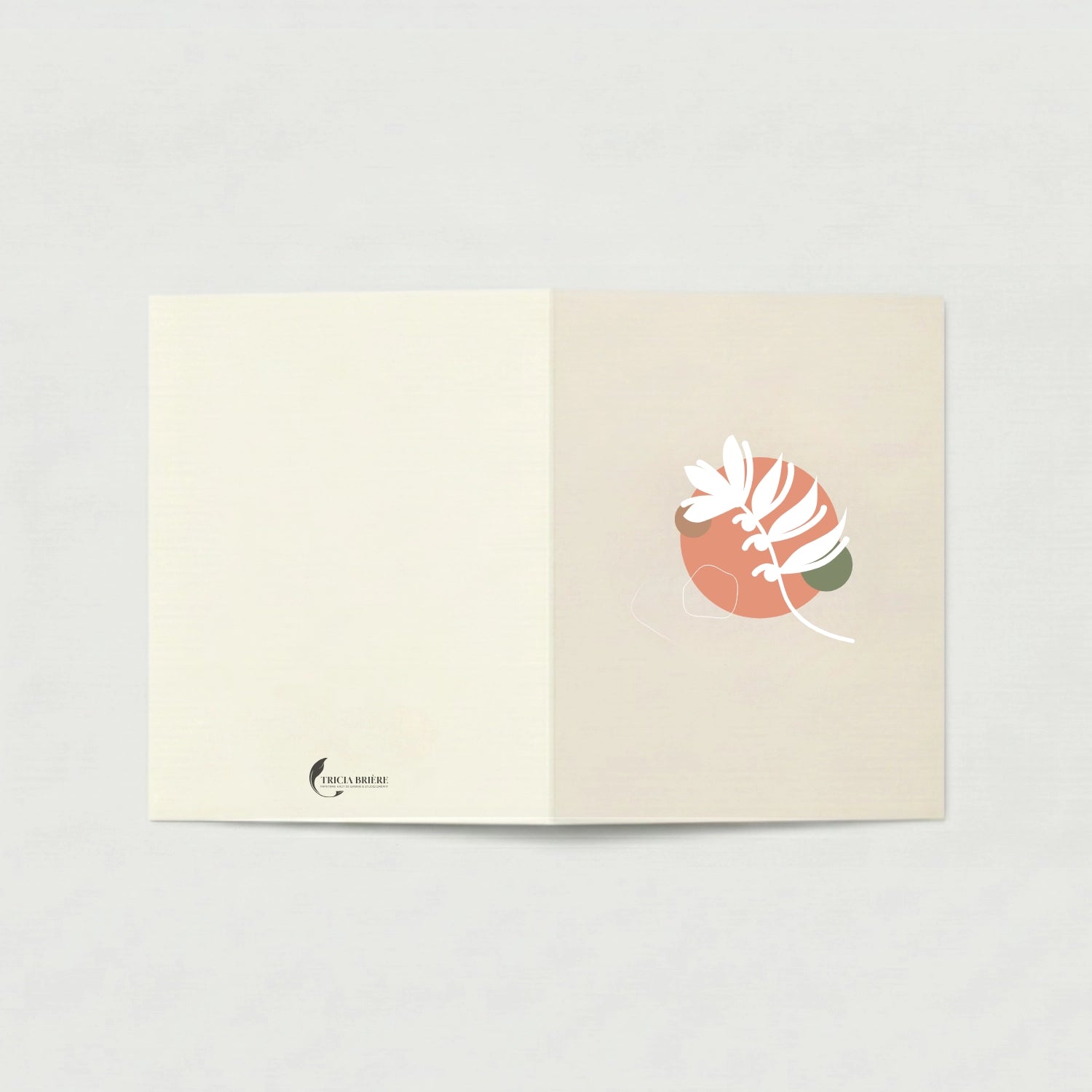 Carte de vœux ouverte à plat sur fond gris clair. La page de gauche est ivoire uni avec le logo Tricia Brière en bas à gauche. La page de droite, en beige rosé, présente une illustration botanique abstraite : un cercle terracotta avec des formes végétales blanches stylisées et un accent vert sauge.