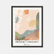 Affiche « Océan & Évanescence » de Tricia Brière dans un cadre en bois noir mat sur fond gris clair. Illustration abstraite aux formes organiques rose poudré, vert sauge, ocre et bleu-vert avec motifs botaniques et ligne de flot ondulée.