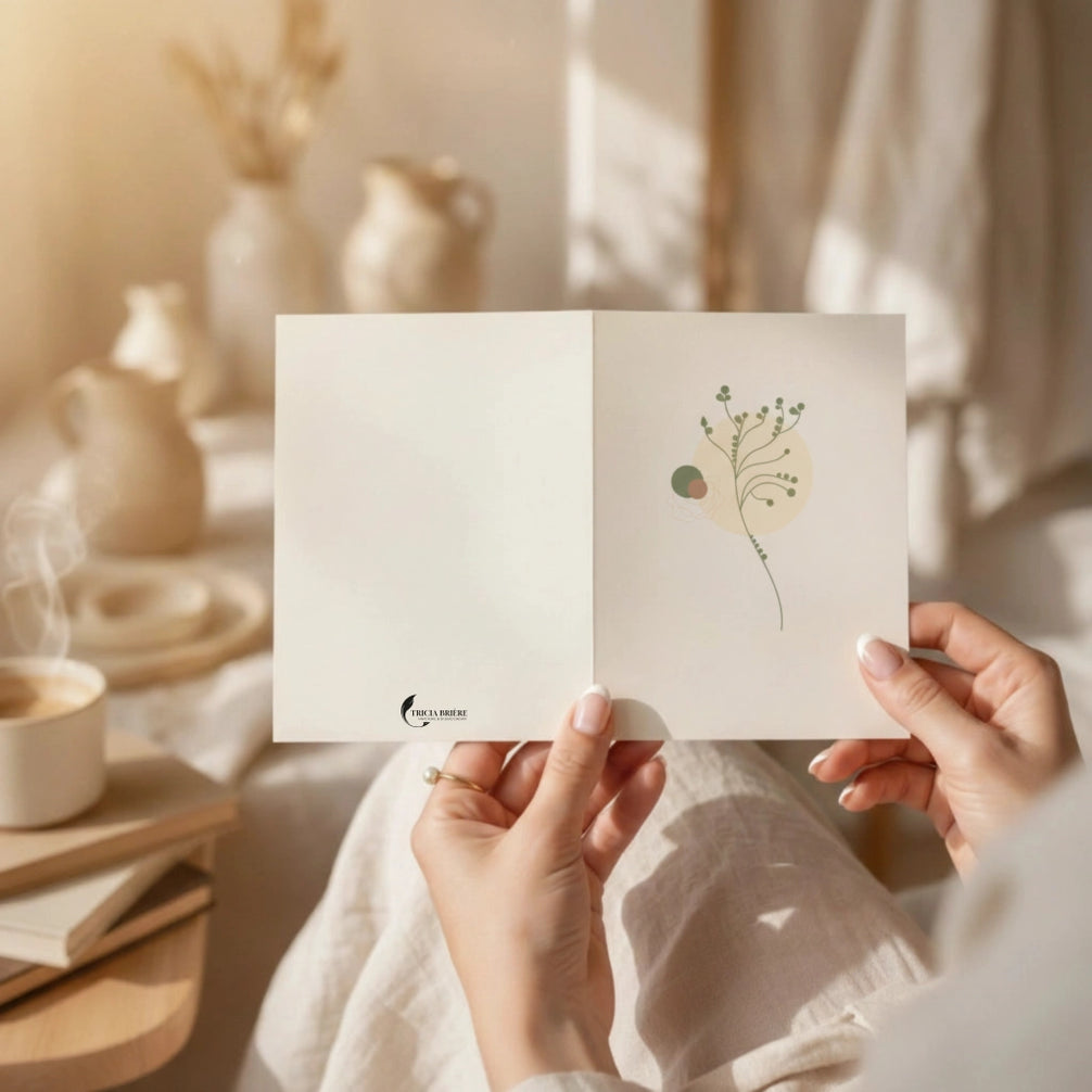 Mains tenant une carte de vœux ouverte au design botanique minimaliste sur fond beige chaleureux, avec le logo Tricia Brière visible au bas.