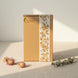 Boîte cadeau kraft Tricia Brière Studio Créatif avec bande florale botanique, mise en scène avec fleurs séchées et eucalyptus sur lin, lumière matinale — emballage papeterie et maroquinerie premium, Canada