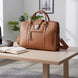 Sac en cuir brun posé dans un espace de travail soigné